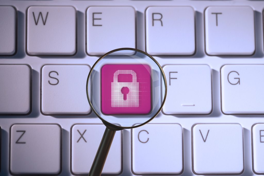 composite of padlock symbol on keyboard with magnifying glass