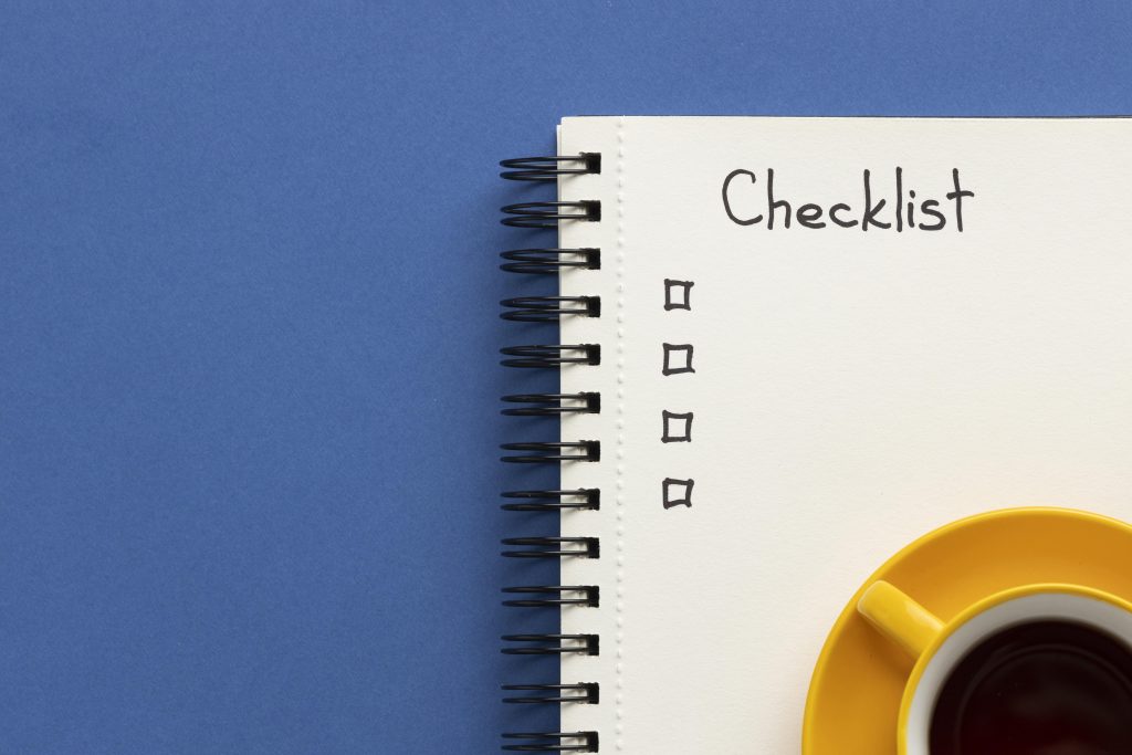 Cuaderno con lista de tareas pendientes en el escritorio con una taza de café
